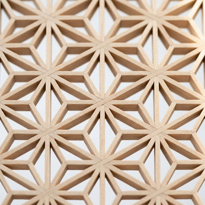 Extreme close-up of completed kumiko asa-no-ha lattice pattern showing precise basswood joinery