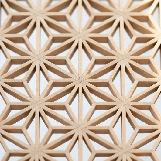 Extreme close-up of completed kumiko asa-no-ha lattice pattern showing precise basswood joinery